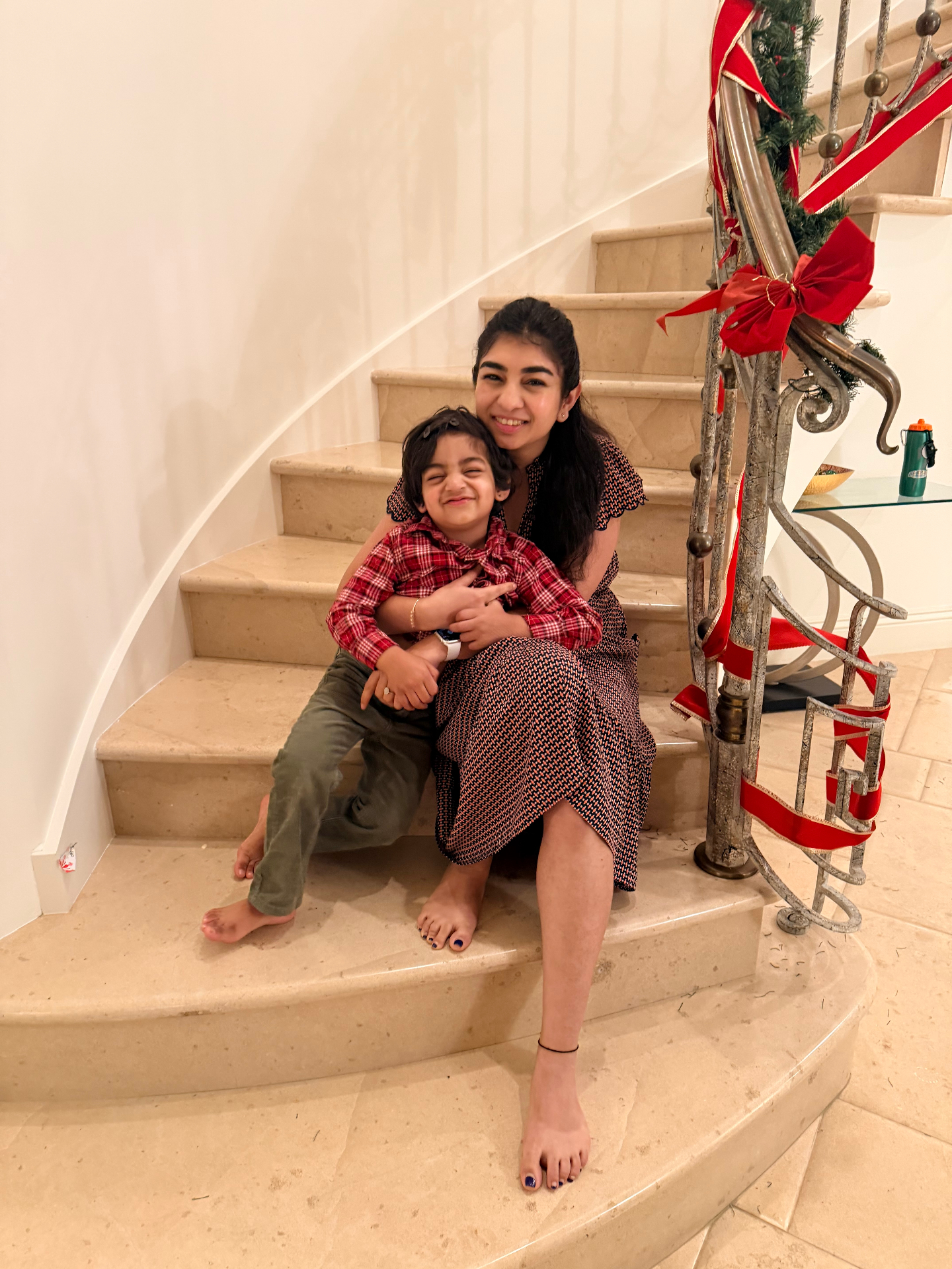 Shivani sitting on a staircase with her smiling toddler